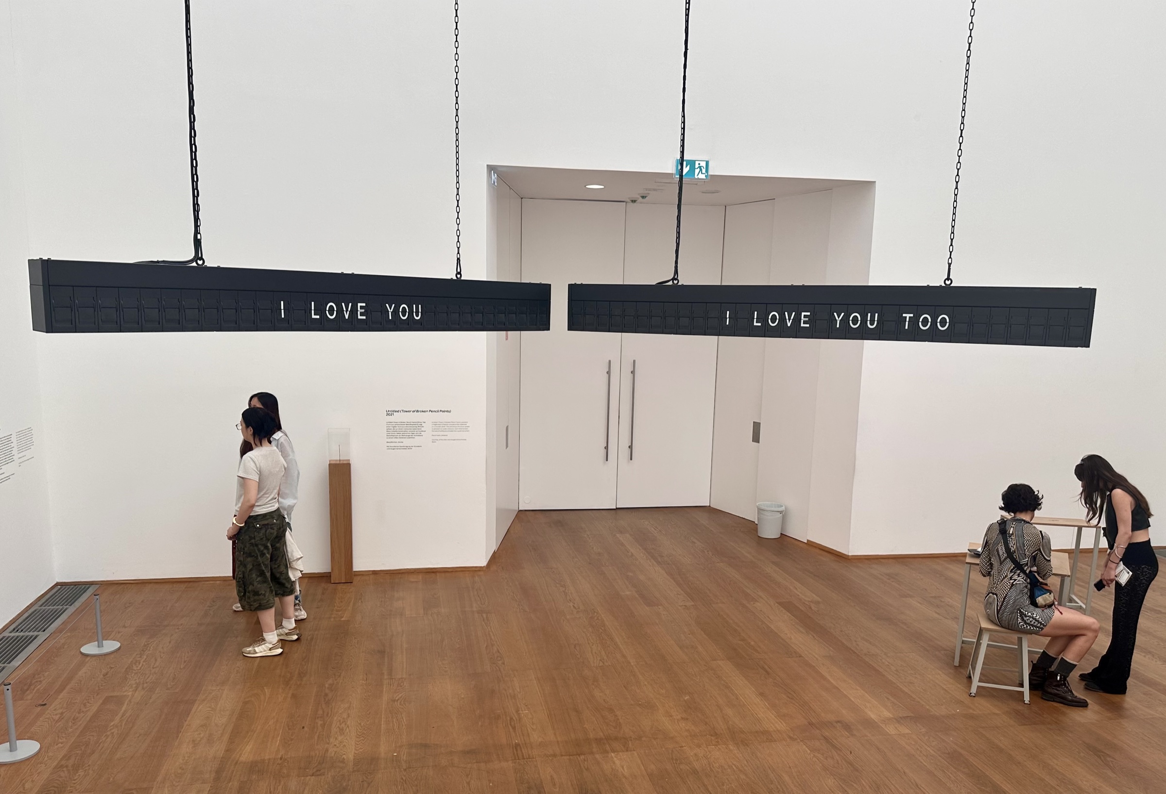 Shilpa Gupta, StillTheyKnowNotWhatIDream; Untitled: two suspended flap boards reading “I LOVE YOU” and “I LOVE YOU TOO” in a gallery at Hamburger Bahnhof